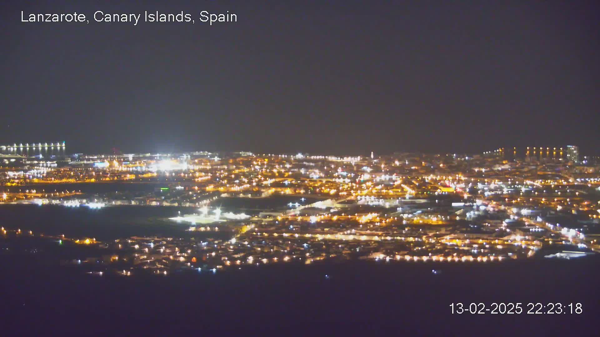 A nighttime, aerial view of a city with many illuminated buildings and streets.