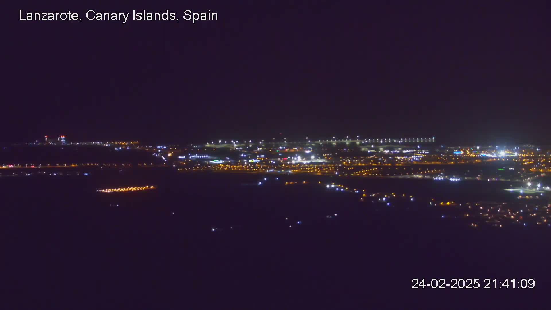 A nighttime, long-distance view of a city illuminated by numerous lights.