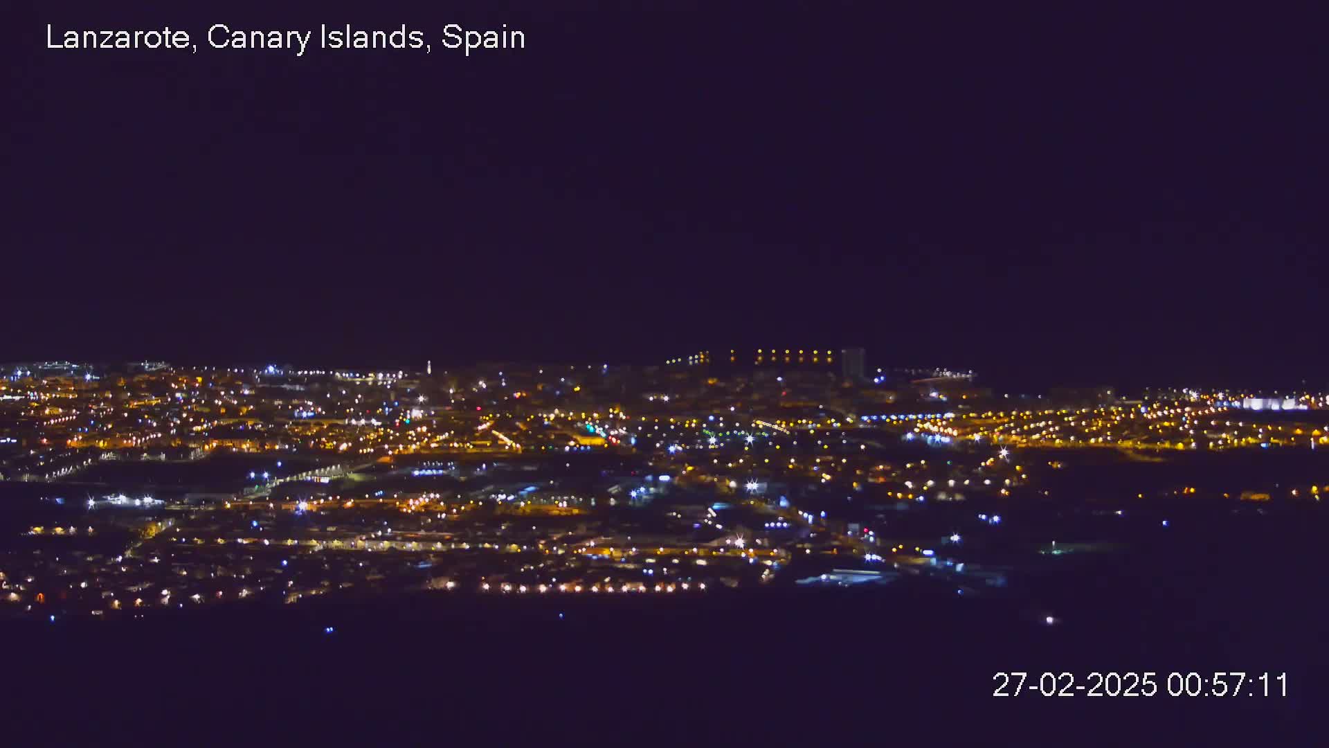 A sprawling city illuminated at night under a clear, dark sky.