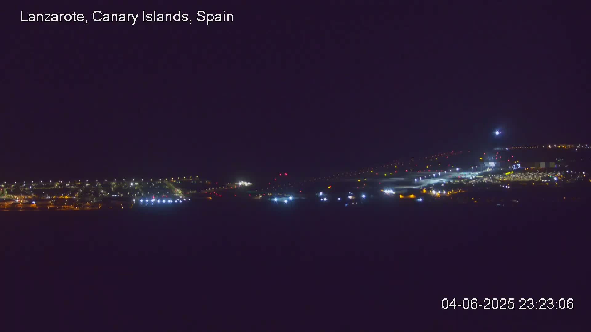 A nighttime long shot of an airport with its lights illuminated under a clear, dark sky.