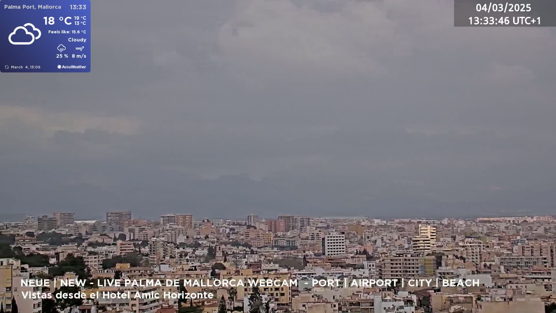 A cloudy, overcast view of a city sprawling across a coastal plain under a gray sky.