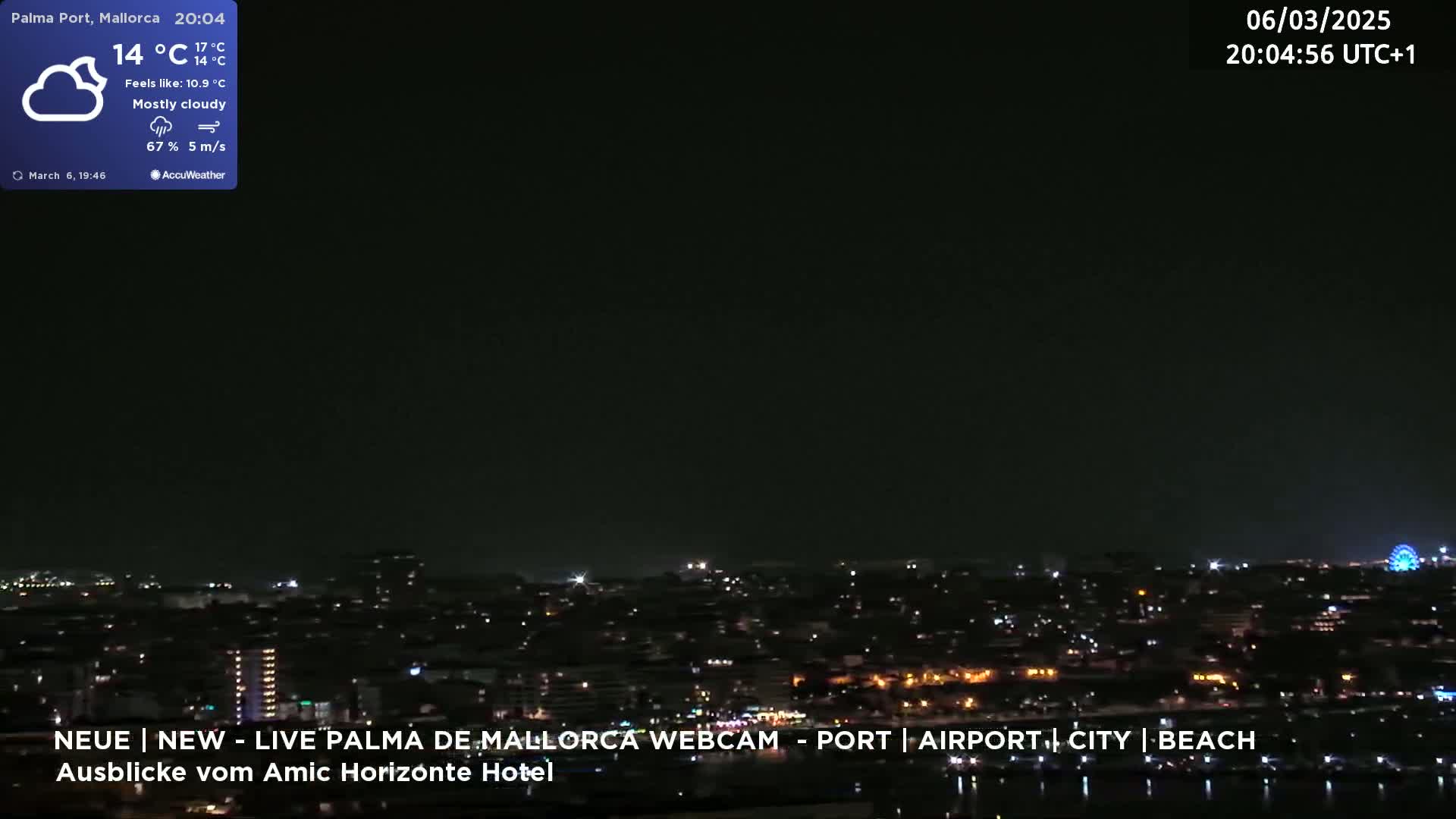 A mostly cloudy night scene shows a cityscape illuminated with city lights, including a Ferris wheel, under a dark sky.