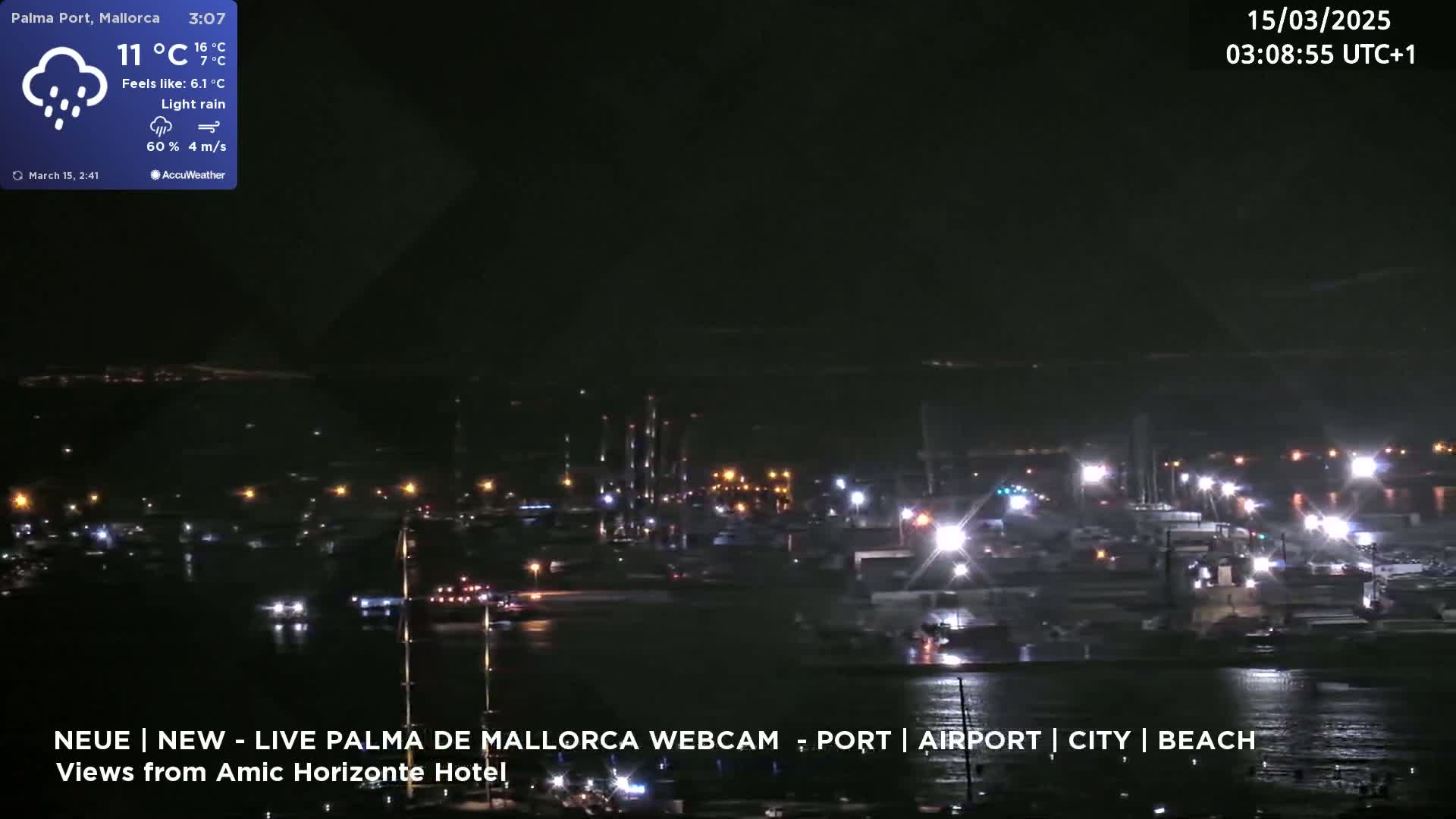 A nighttime harbor scene with light rain and many lights visible along the waterfront.
