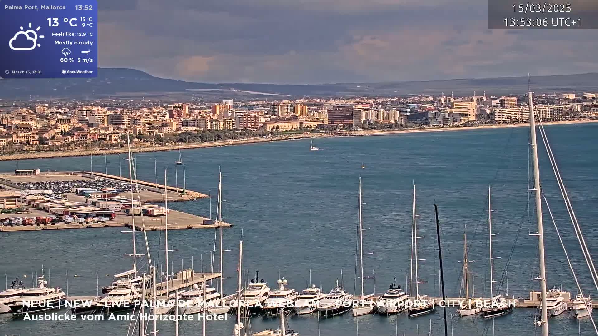 A mostly cloudy day shows a harbor filled with sailboats and yachts, next to a city on a calm bay.