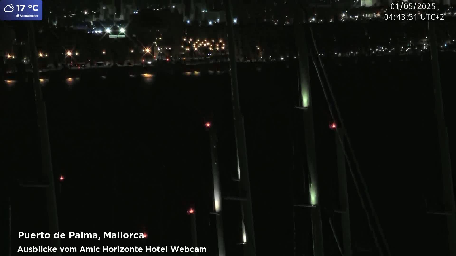 A nighttime view of a city harbor with scattered lights, illuminated by a warm 17°C air temperature.