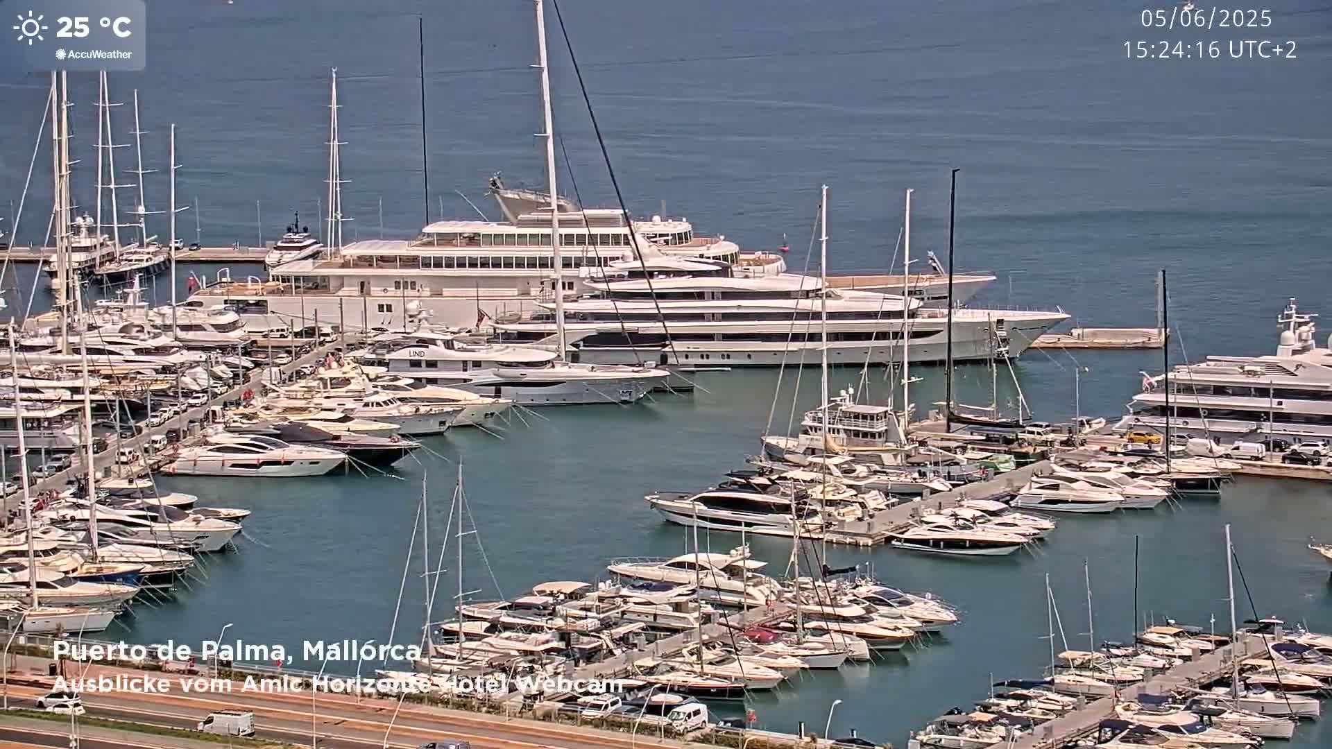 A marina filled with numerous yachts and sailboats on a sunny day with a temperature of 25 degrees Celsius.
