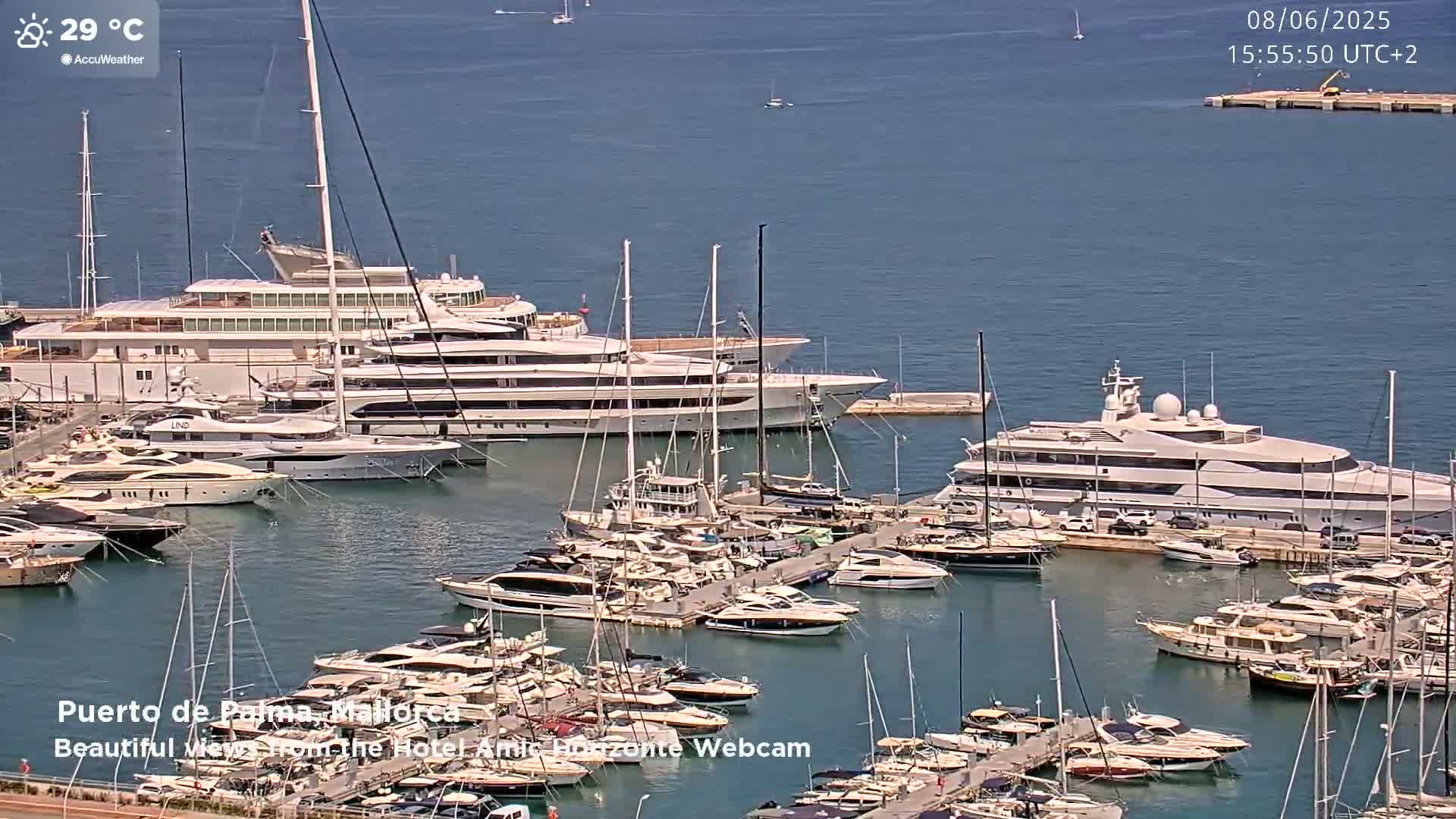 A harbor filled with numerous yachts and sailboats on a sunny day with a water temperature of 29°C.