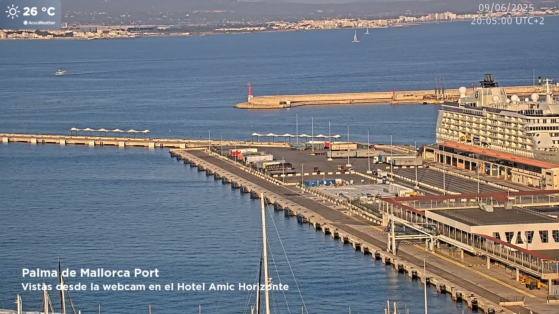 A cruise ship is docked at a port on a sunny day with calm water.
