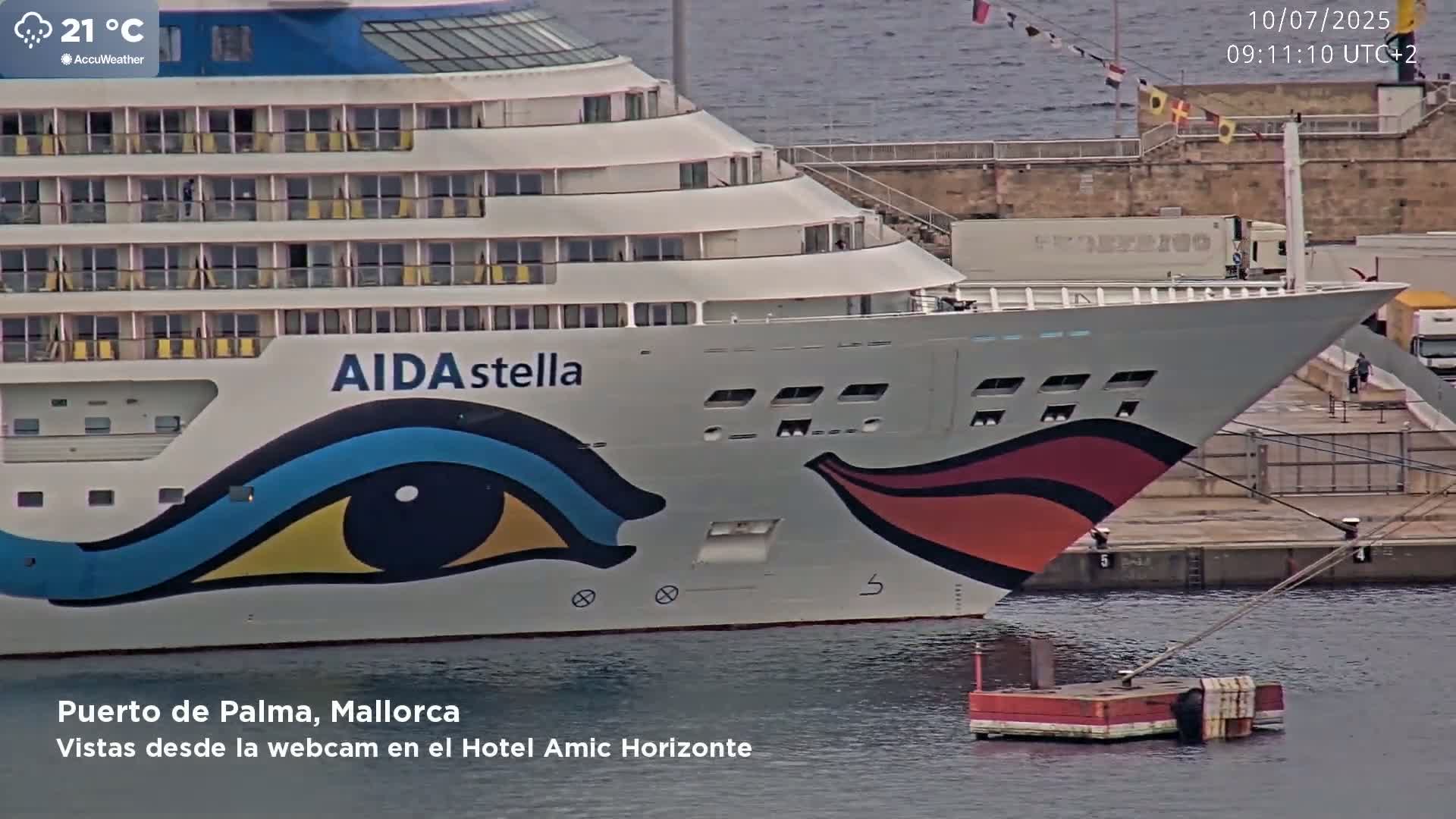 A large cruise ship, the AIDA stella, is docked at a port on a partly cloudy day.