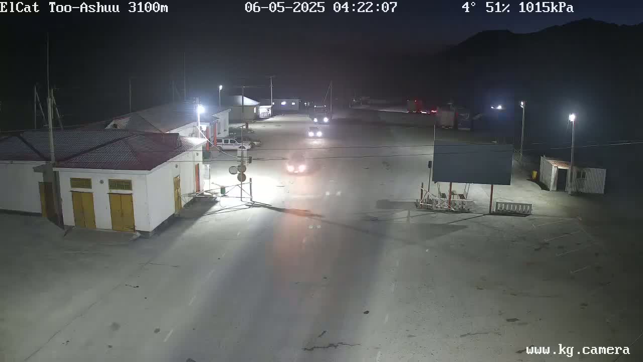 At night, under a clear sky with a temperature of 4° and 51% humidity, several vehicles are visible on a roadway near some buildings and streetlights.