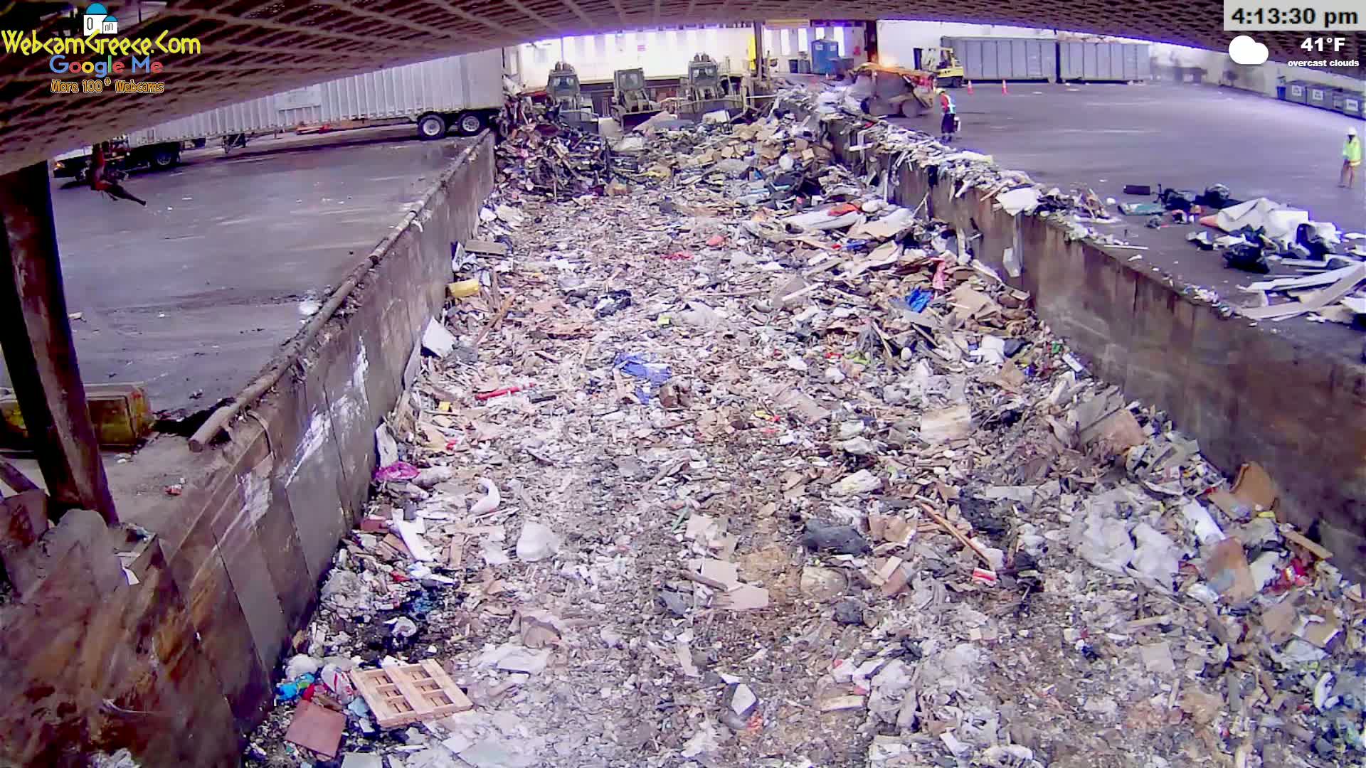 A large amount of debris and trash fills a concrete-walled pit under overcast skies, with a temperature of 41°F.