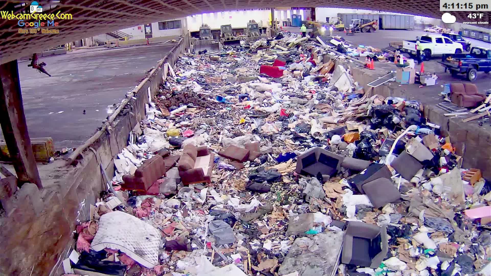 A large pile of discarded furniture and assorted trash sits in an outdoor, overcast area at 43°F.