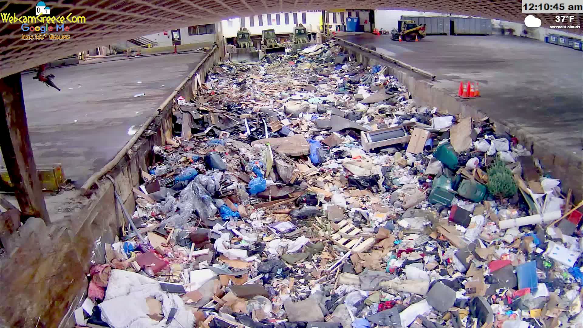 A large pile of refuse sits in an outdoor waste disposal area under overcast skies, with a temperature of 37°F.