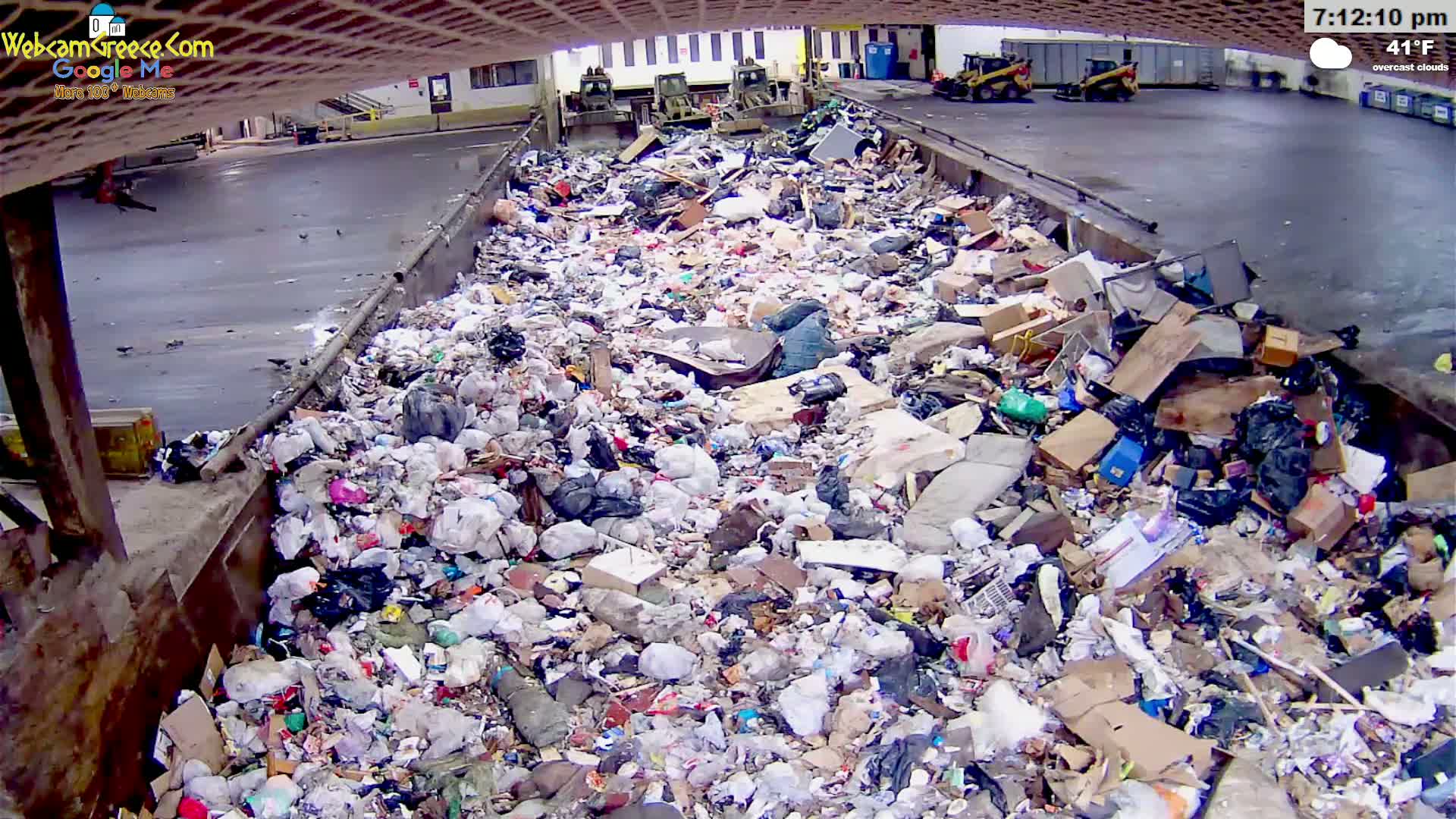 A large pile of garbage sits in a concrete trough under overcast skies at 41°F.