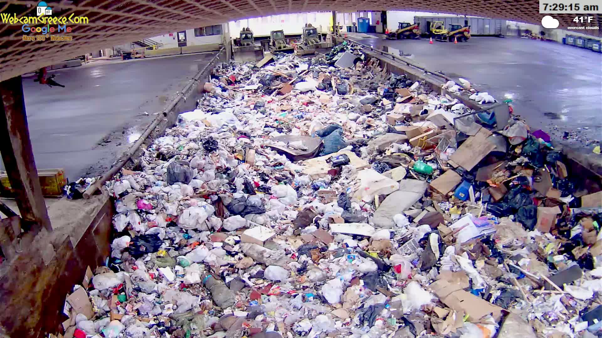 A large pile of trash sits inside a metal container under an overcast sky, with the temperature at 41°F.