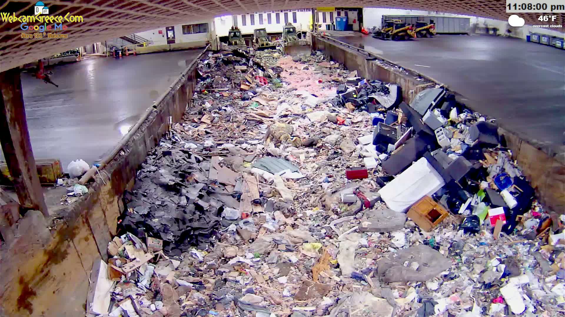 A large amount of refuse is piled in a long, concrete trough under overcast skies at 46°F.
