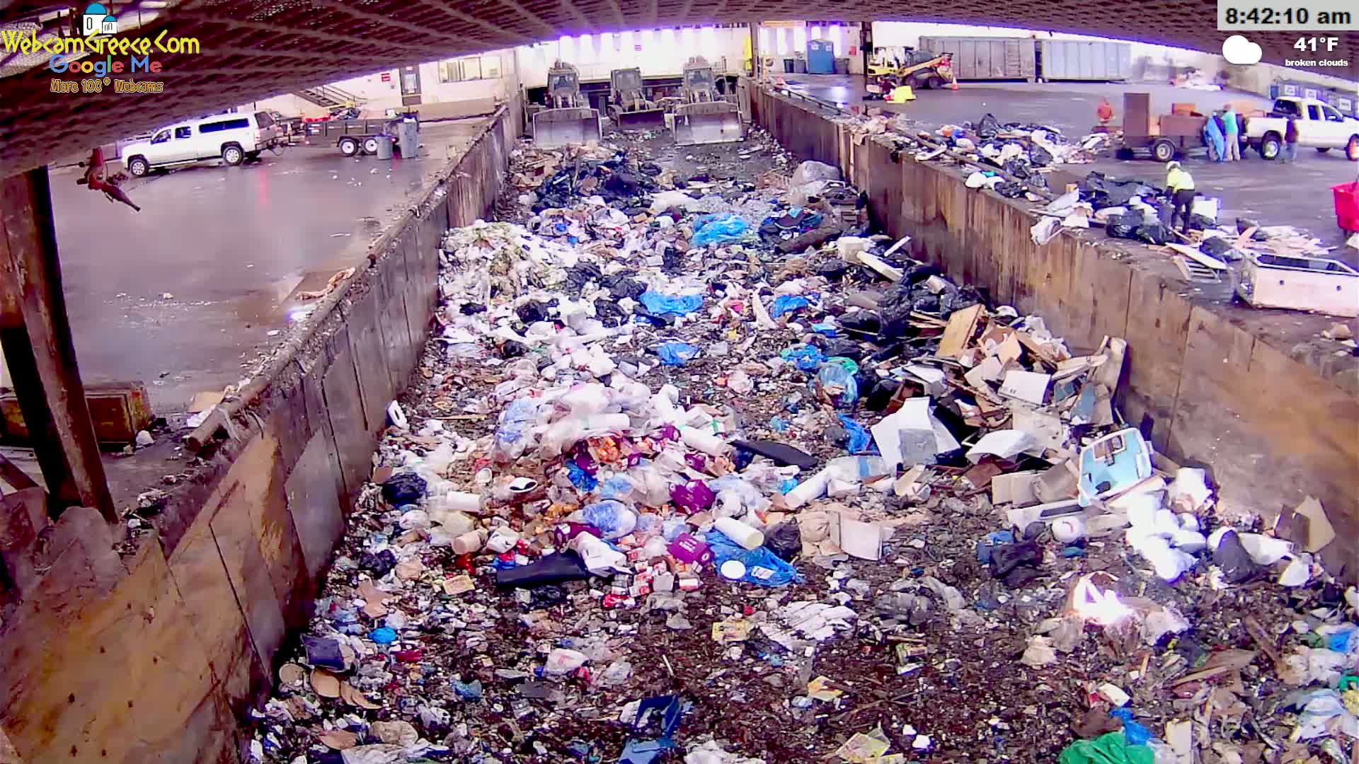 A large amount of trash and debris fills a concrete-walled bin outdoors under broken clouds on a 41°F day.
