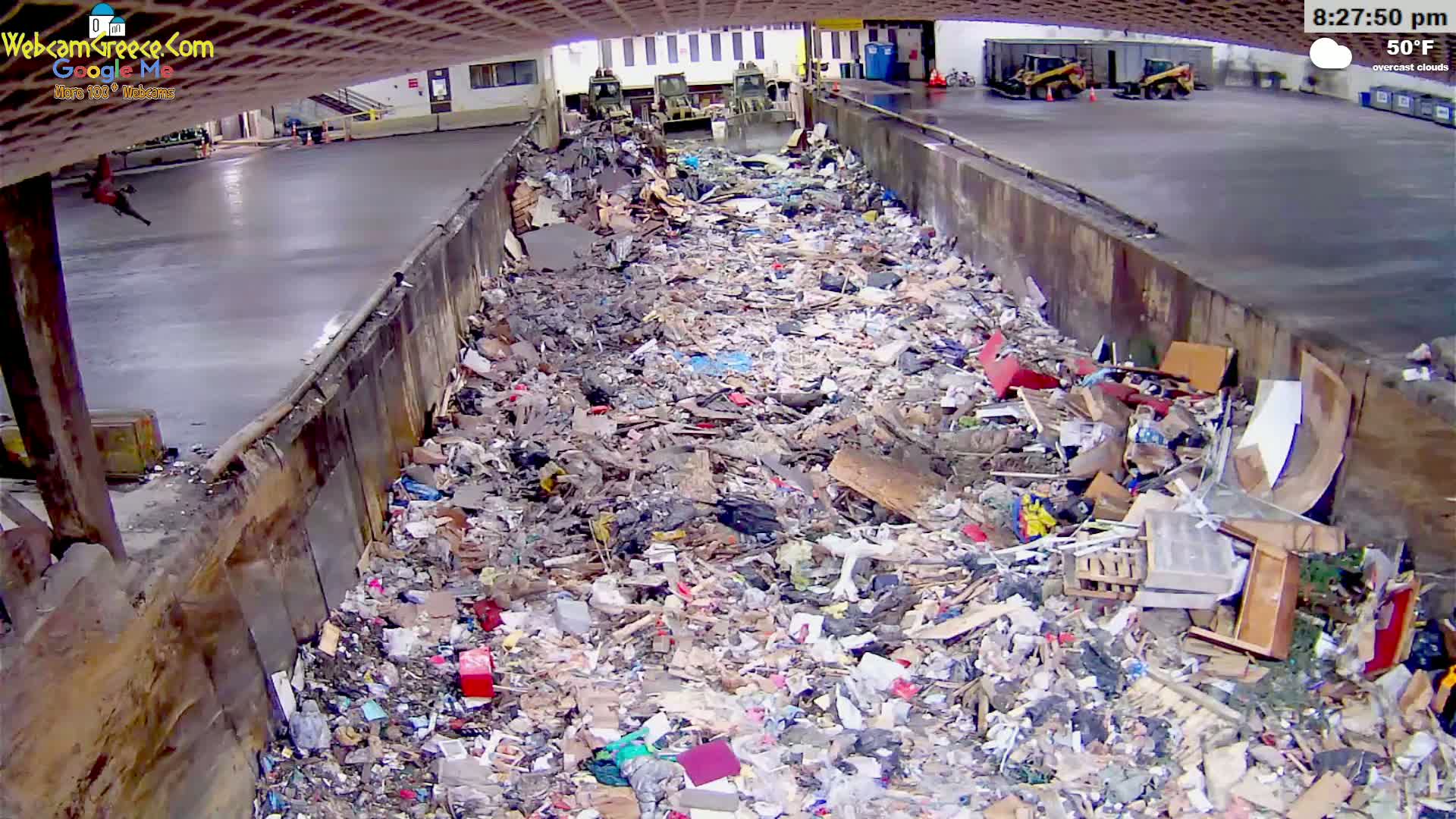 A large pile of refuse fills a concrete trough under an overcast sky at 50°F.