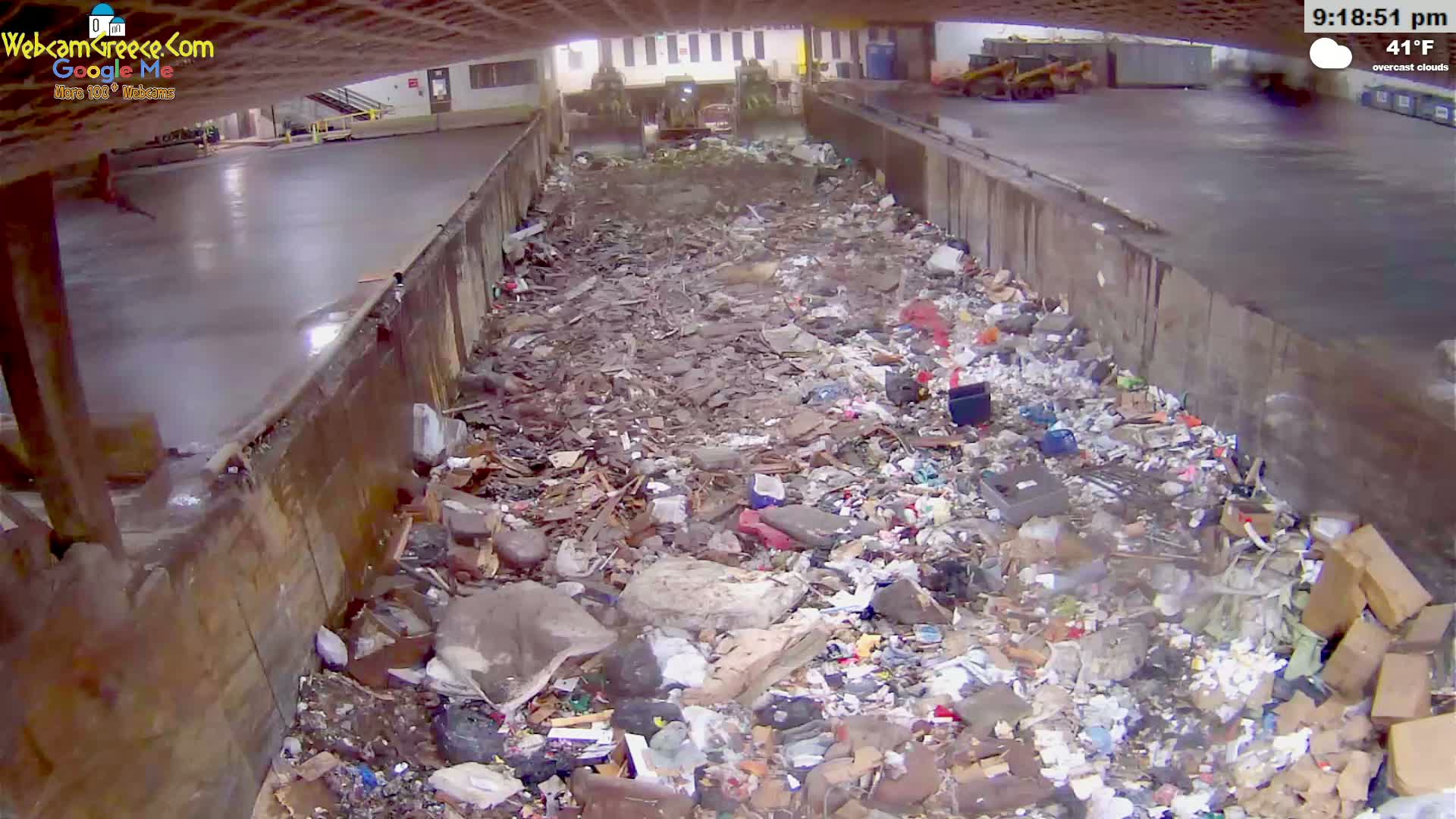 A large pile of trash and debris fills a concrete trough under overcast skies at 41°F.