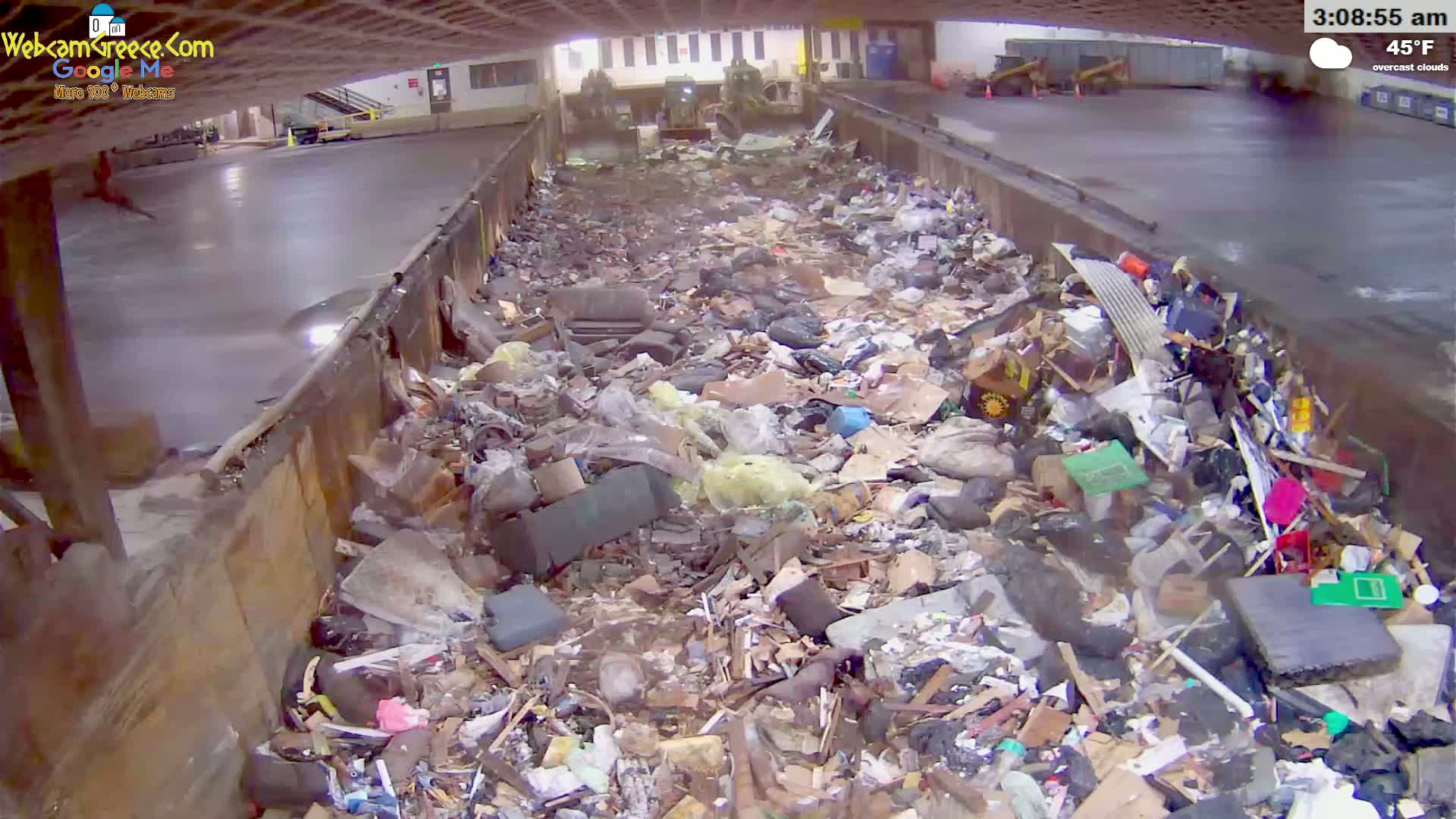 A large amount of trash and debris fills a long, narrow concrete trough under overcast skies at 45°F.