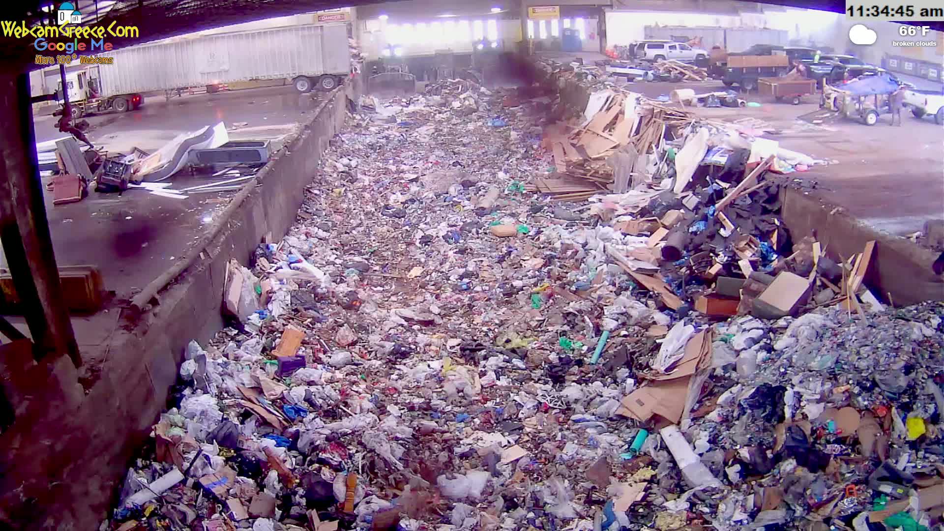 A large pile of mixed garbage is seen in an outdoor area under broken clouds on a 66°F day.
