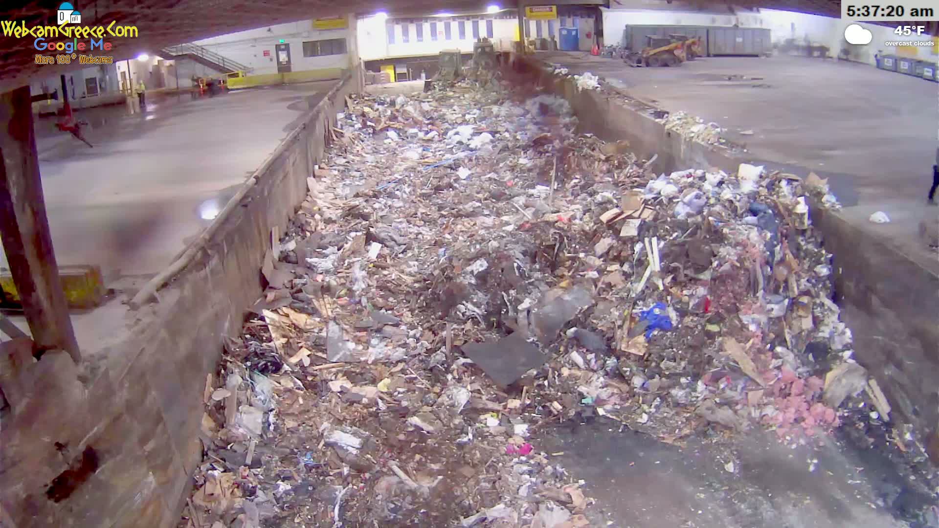 A large pile of trash sits in an indoor waste receptacle under overcast skies at 45°F.