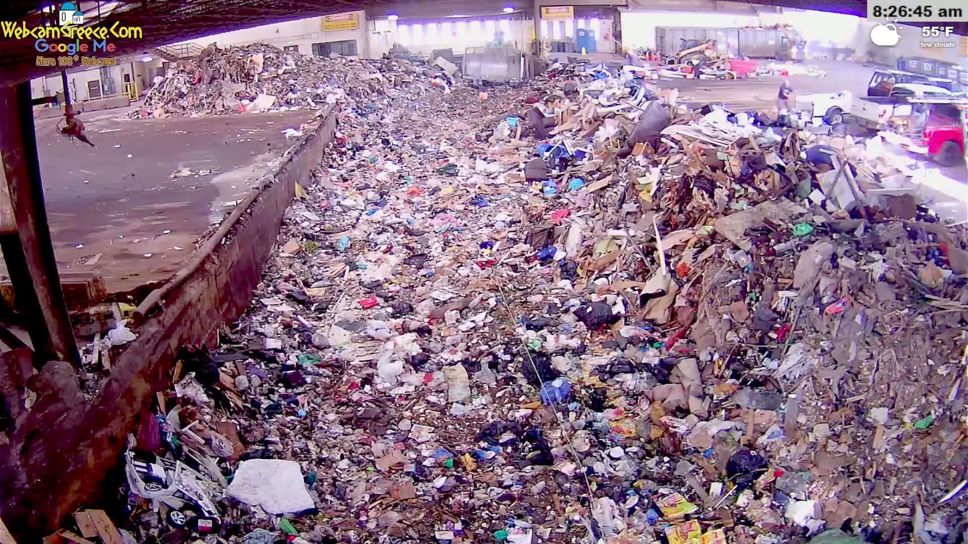 A large amount of trash and debris is piled up in an outdoor area under an overcast sky.