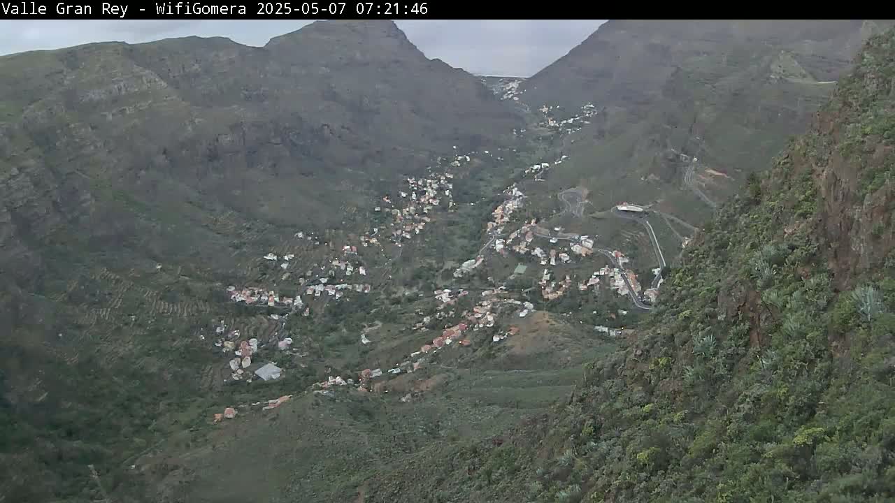 A mountainous valley town is viewed from above on an overcast day.
