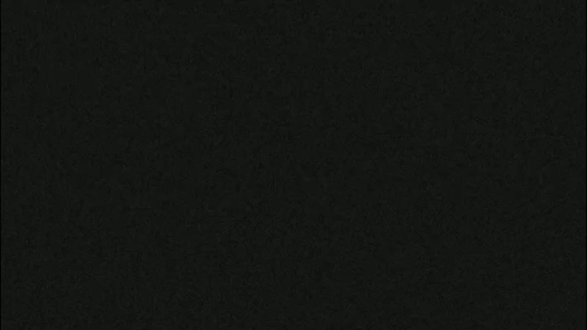 The image is a solid dark gray or black background with a slightly textured surface.