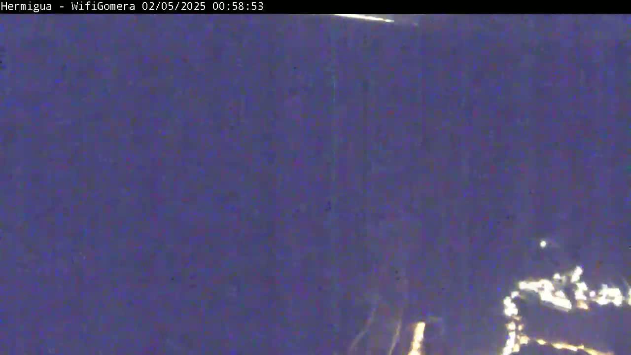 A blurry, dark purple nighttime image shows a few small, indistinct lights in the bottom right corner.