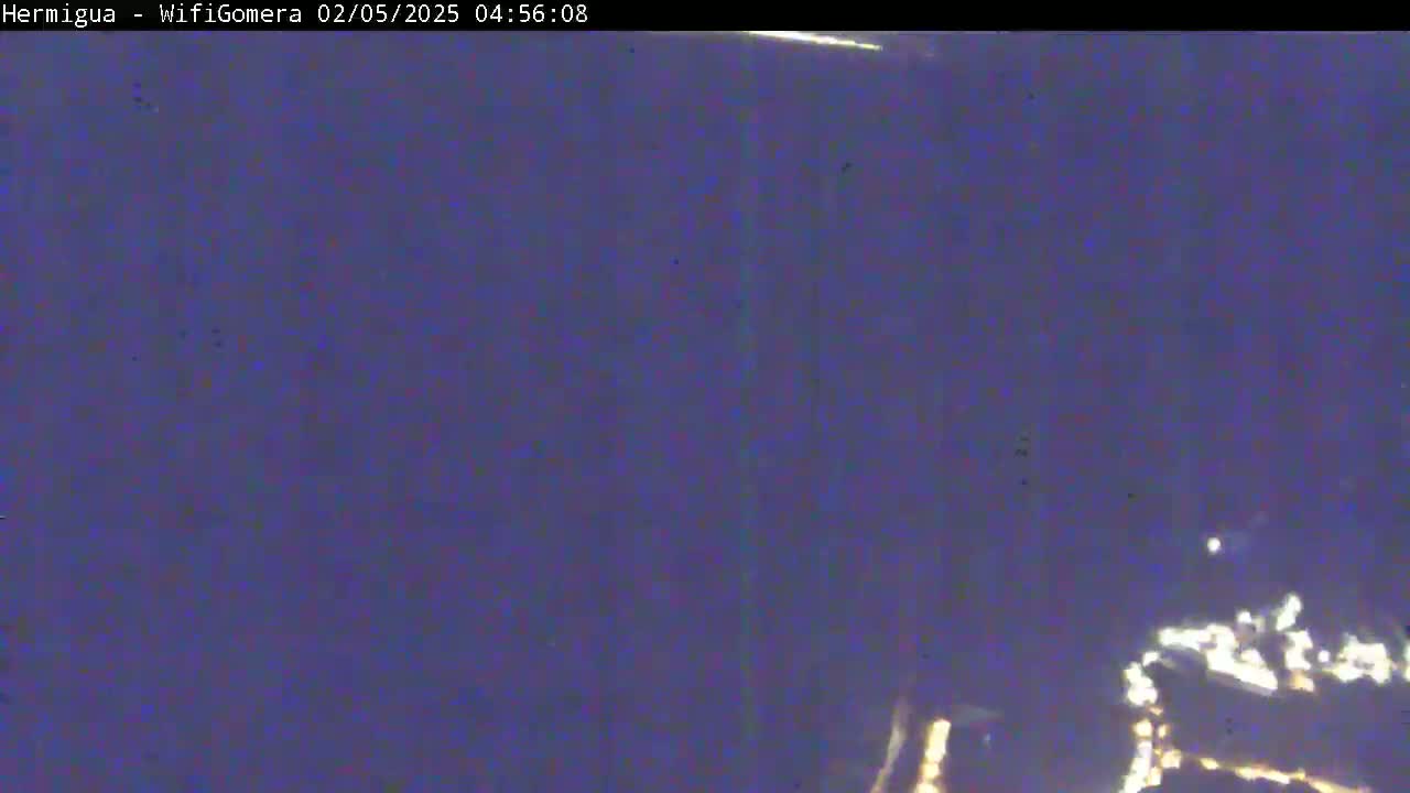 A blurry, dark-purple image shows a small collection of lights in the lower-right corner, possibly at night.