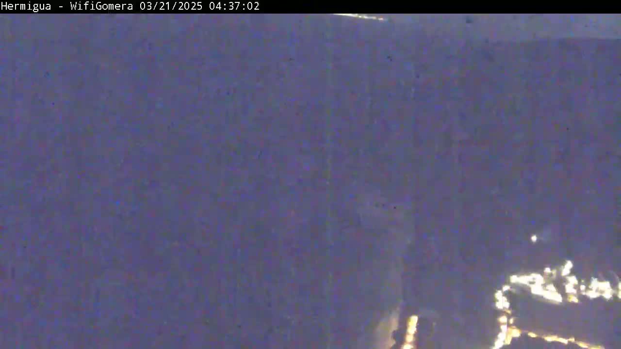 A blurry, dark image shows an indistinct, possibly nighttime scene with some faint, bright lights in the lower right corner.