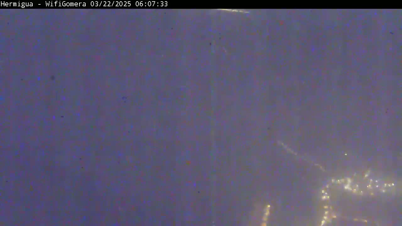 A hazy, dark-purple nighttime scene shows distant, faint lights possibly from a city or town.