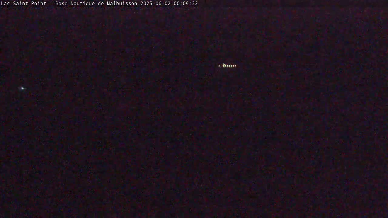 A nighttime, dark image shows a few distant lights in the sky.
