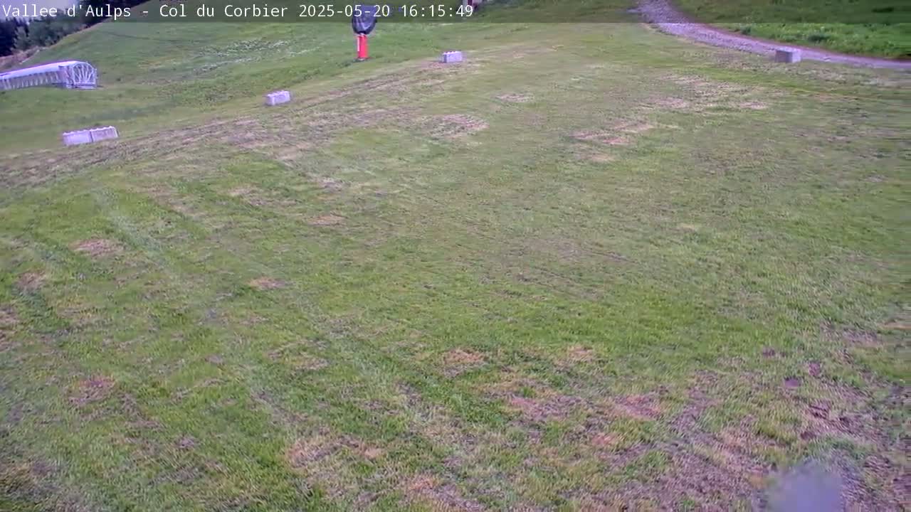 A grassy hillside with several concrete blocks scattered across it, viewed from above on an overcast day.