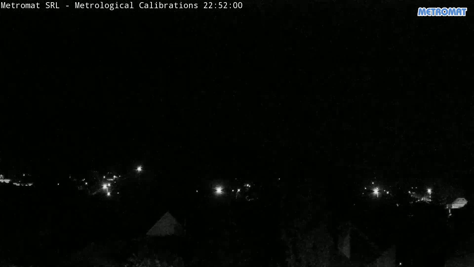 A nighttime, low-light view shows a scattering of small lights across a dark landscape.
