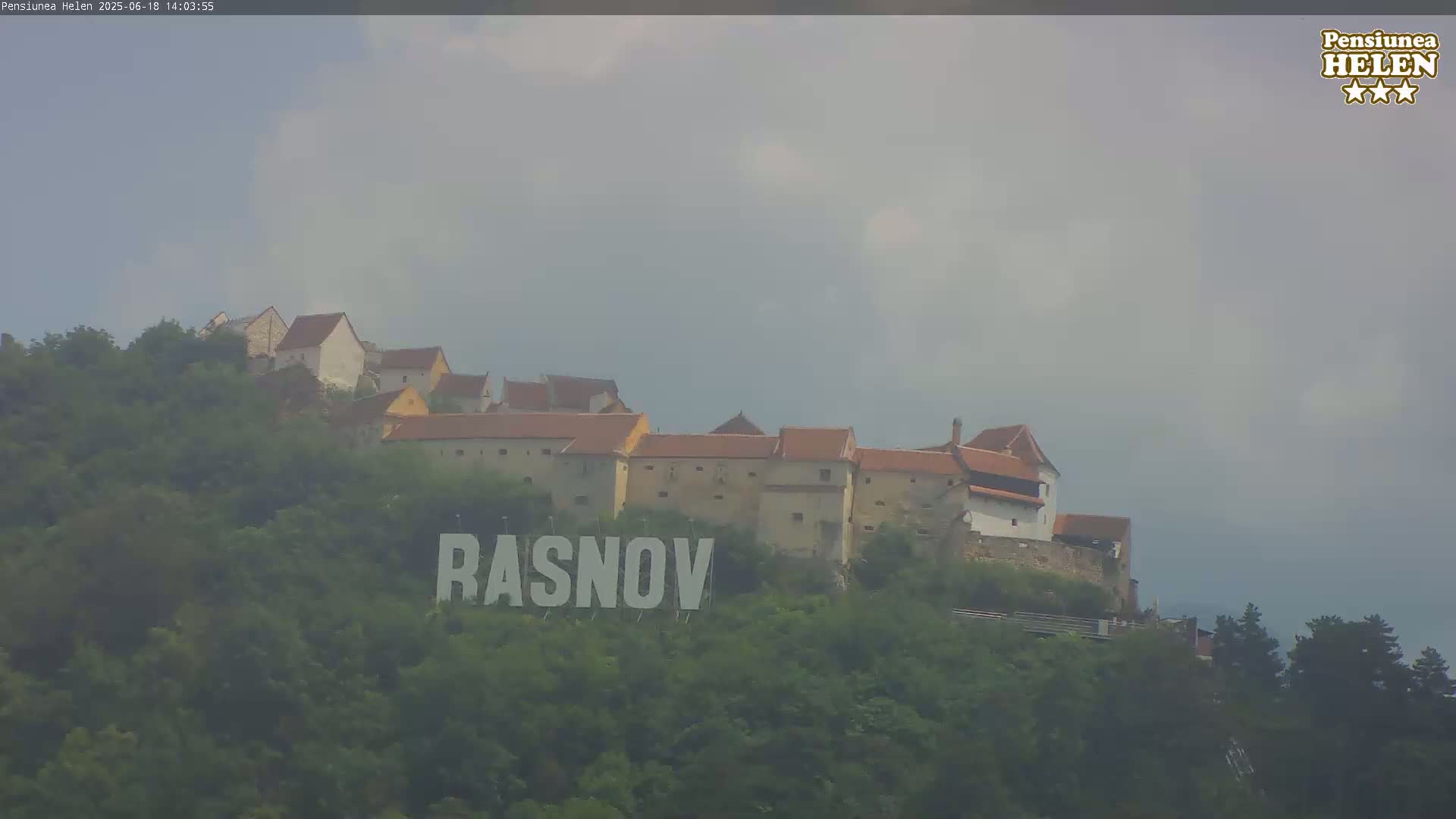 A hilltop castle with red-tiled roofs is visible under an overcast sky, with the name "RASNOV" prominently displayed in large letters at its base.