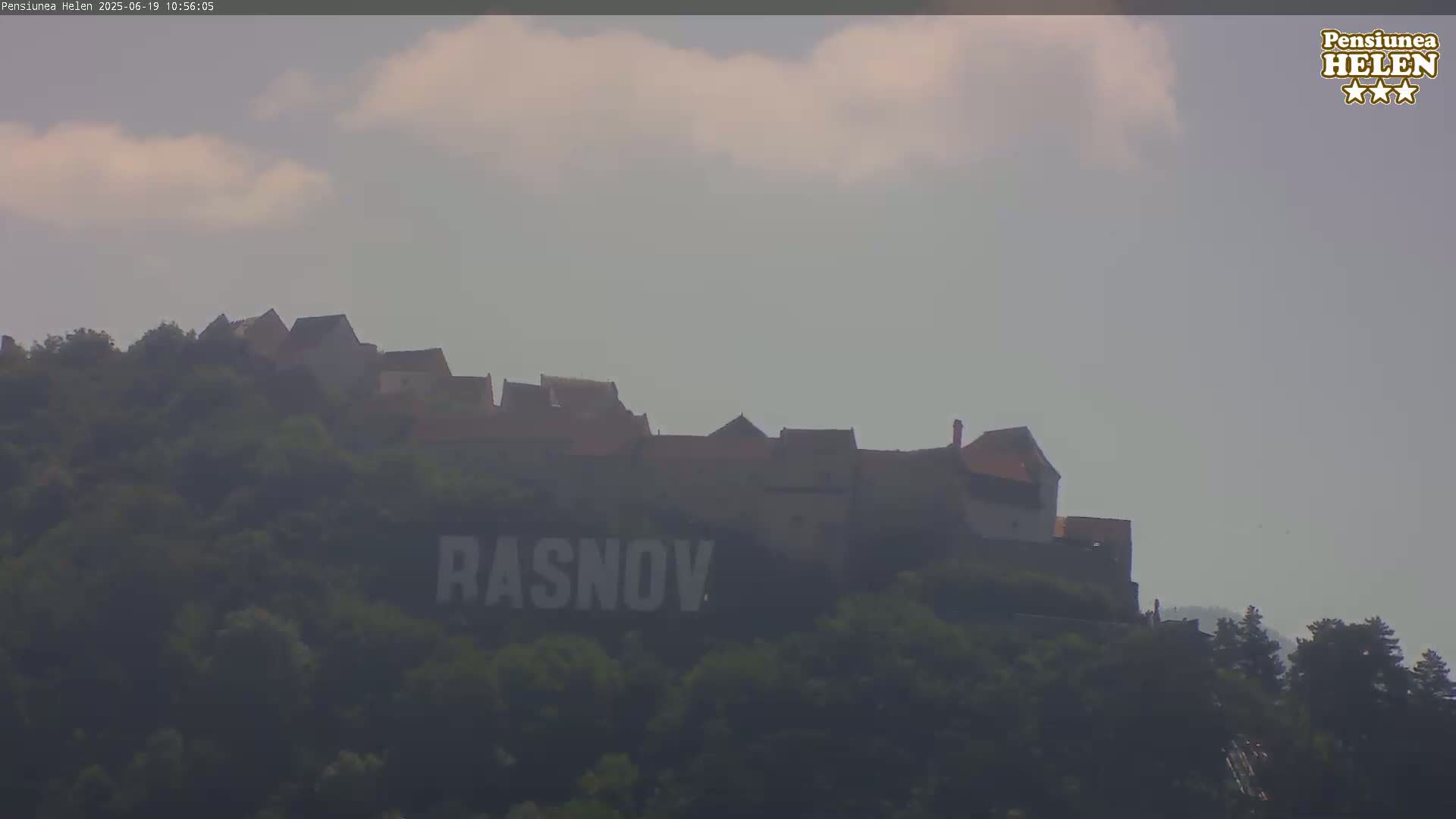 A hilltop castle is visible under a partly cloudy sky, with the name "RASNOV" displayed prominently on the hillside below.