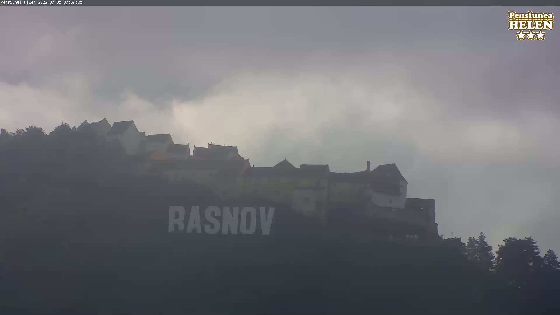 A castle sits atop a hill under a partly cloudy sky.