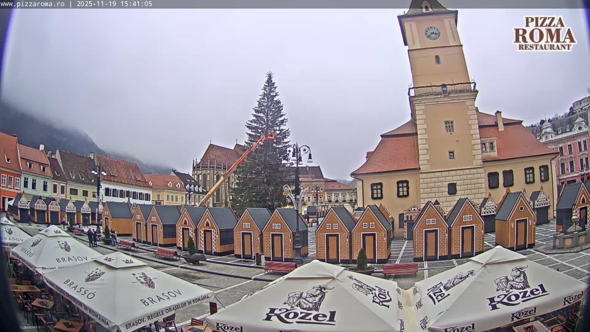 A layered mountain range is silhouetted against a hazy twilight sky that transitions from warm orange at the top to lighter blue-gray near the peaks.