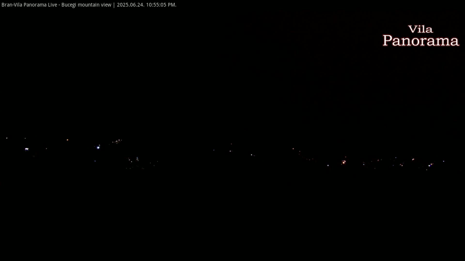 A nighttime view of a distant line of lights on a mountain, under a clear, dark sky.
