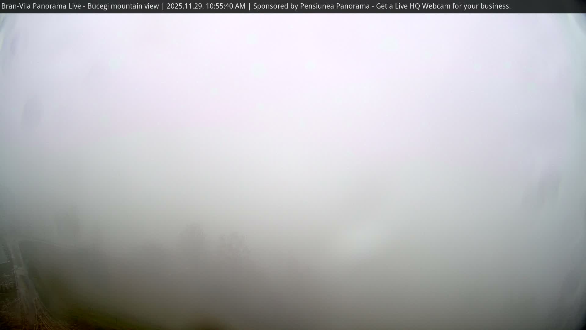 The outdoor scene is almost entirely consumed by dense, white fog, with only a sliver of dark ground and a faint path visible in the bottom-left corner.