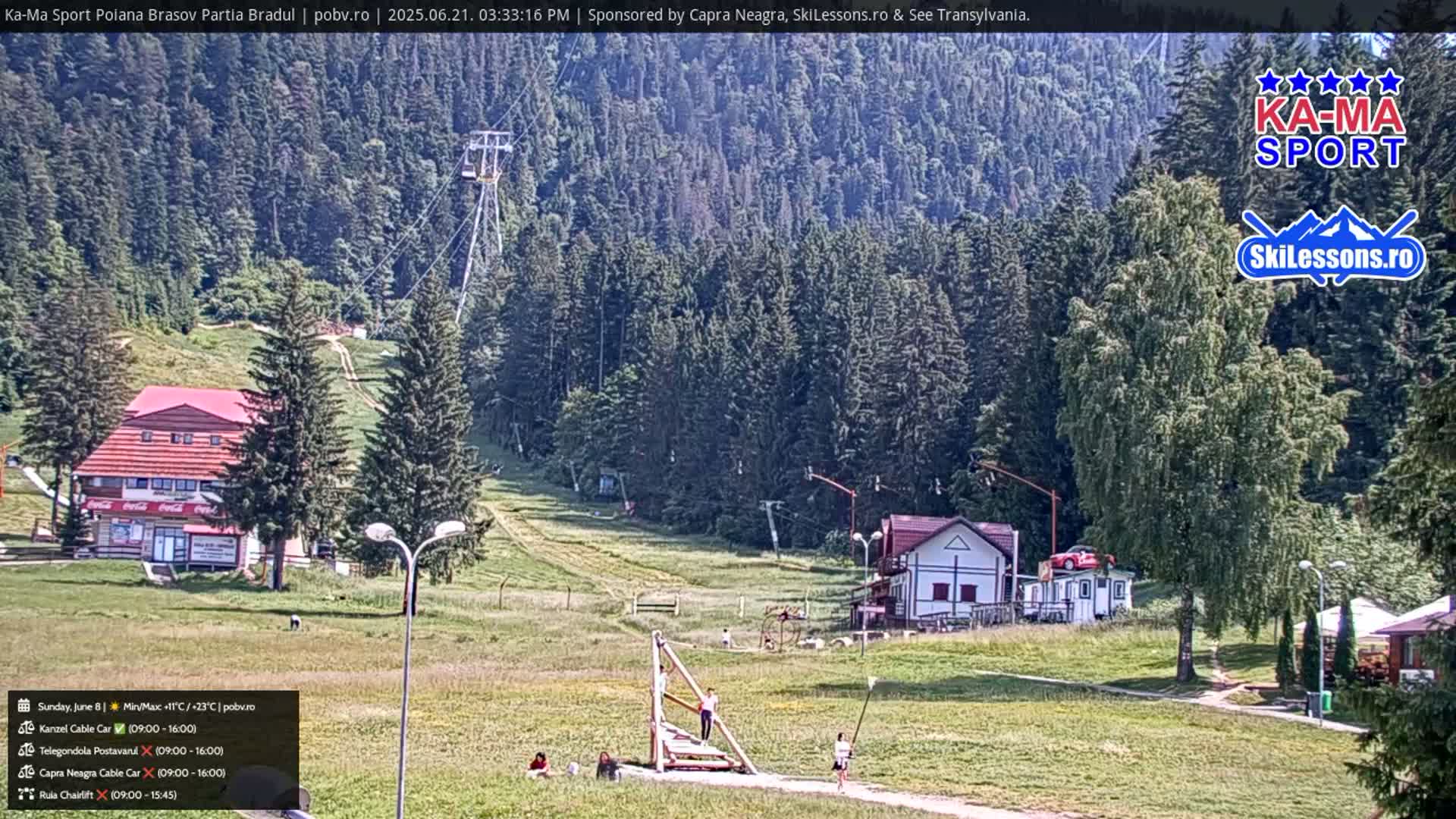 A sunny mountain landscape shows a ski lift, a small building, and several people near a wooden staircase, with a forest in the background.