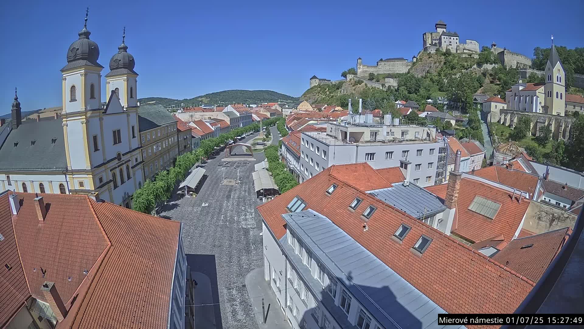 Trenčín, Piaristický kostol sv. Františka Xaverského Church & Trenciansky Hrad (Ttencin Castle) at Mierové námestie Square East View Live Cam - Trencin, Okres Trencin, Slovakia 