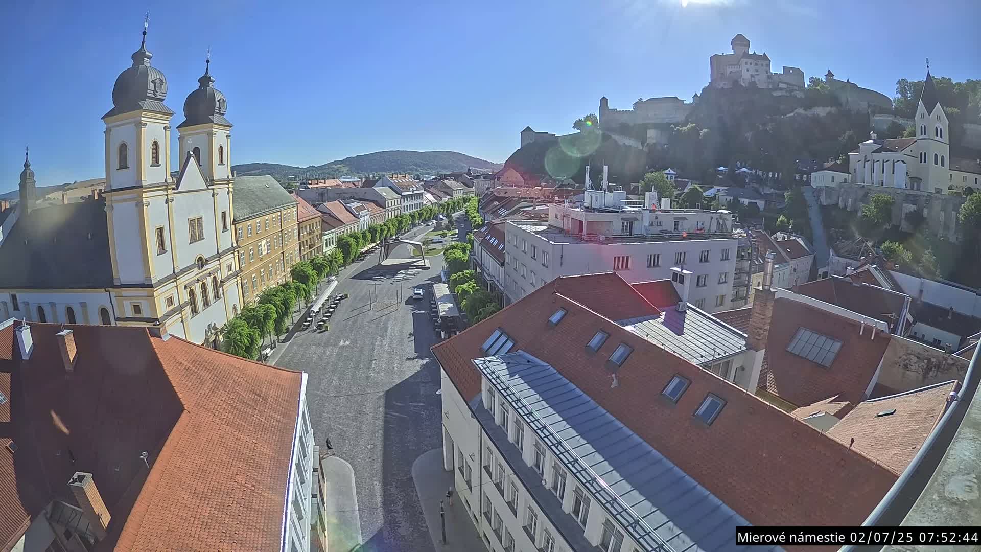 Trenčín, Piaristický kostol sv. Františka Xaverského Church & Trenciansky Hrad (Ttencin Castle) at Mierové námestie Square East View Live Cam - Trencin, Okres Trencin, Slovakia 