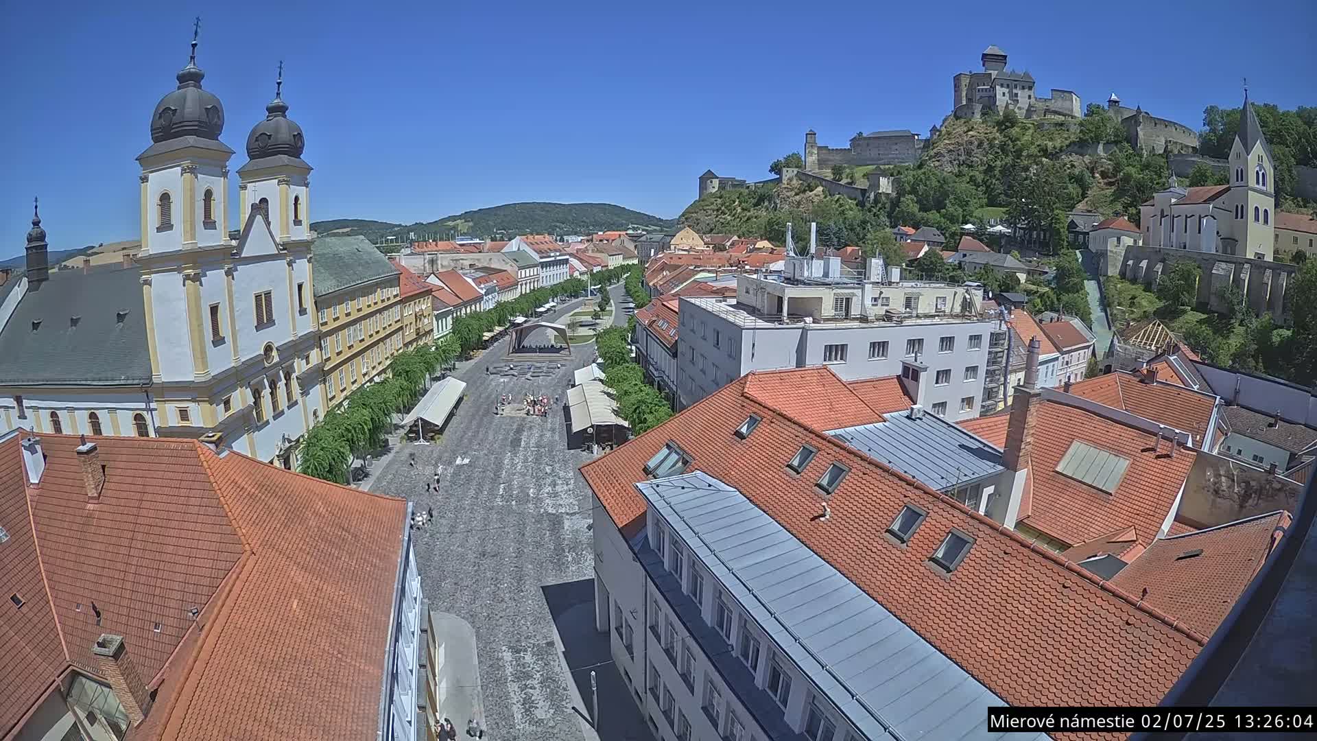 Trenčín, Piaristický kostol sv. Františka Xaverského Church & Trenciansky Hrad (Ttencin Castle) at Mierové námestie Square East View Live Cam - Trencin, Okres Trencin, Slovakia 