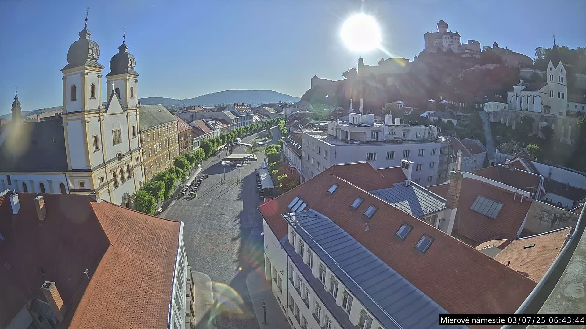 Trenčín, Piaristický kostol sv. Františka Xaverského Church & Trenciansky Hrad (Ttencin Castle) at Mierové námestie Square East View Live Cam - Trencin, Okres Trencin, Slovakia 