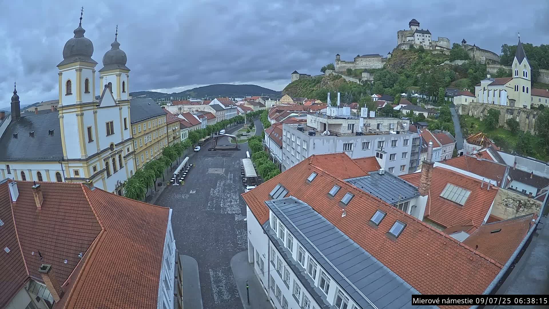 Trenčín, Piaristický kostol sv. Františka Xaverského Church & Trenciansky Hrad (Ttencin Castle) at Mierové námestie Square East View Live Cam - Trencin, Okres Trencin, Slovakia 