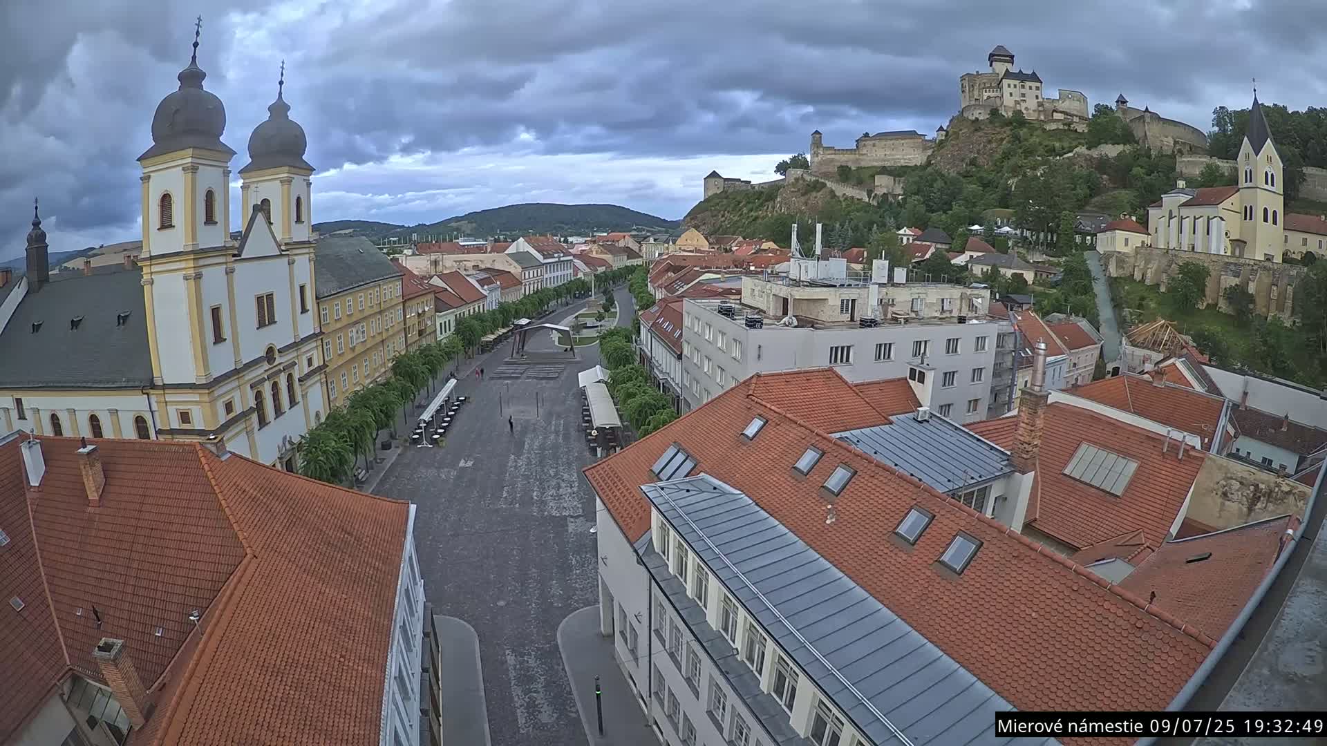 Trenčín, Piaristický kostol sv. Františka Xaverského Church & Trenciansky Hrad (Ttencin Castle) at Mierové námestie Square East View Live Cam - Trencin, Okres Trencin, Slovakia 