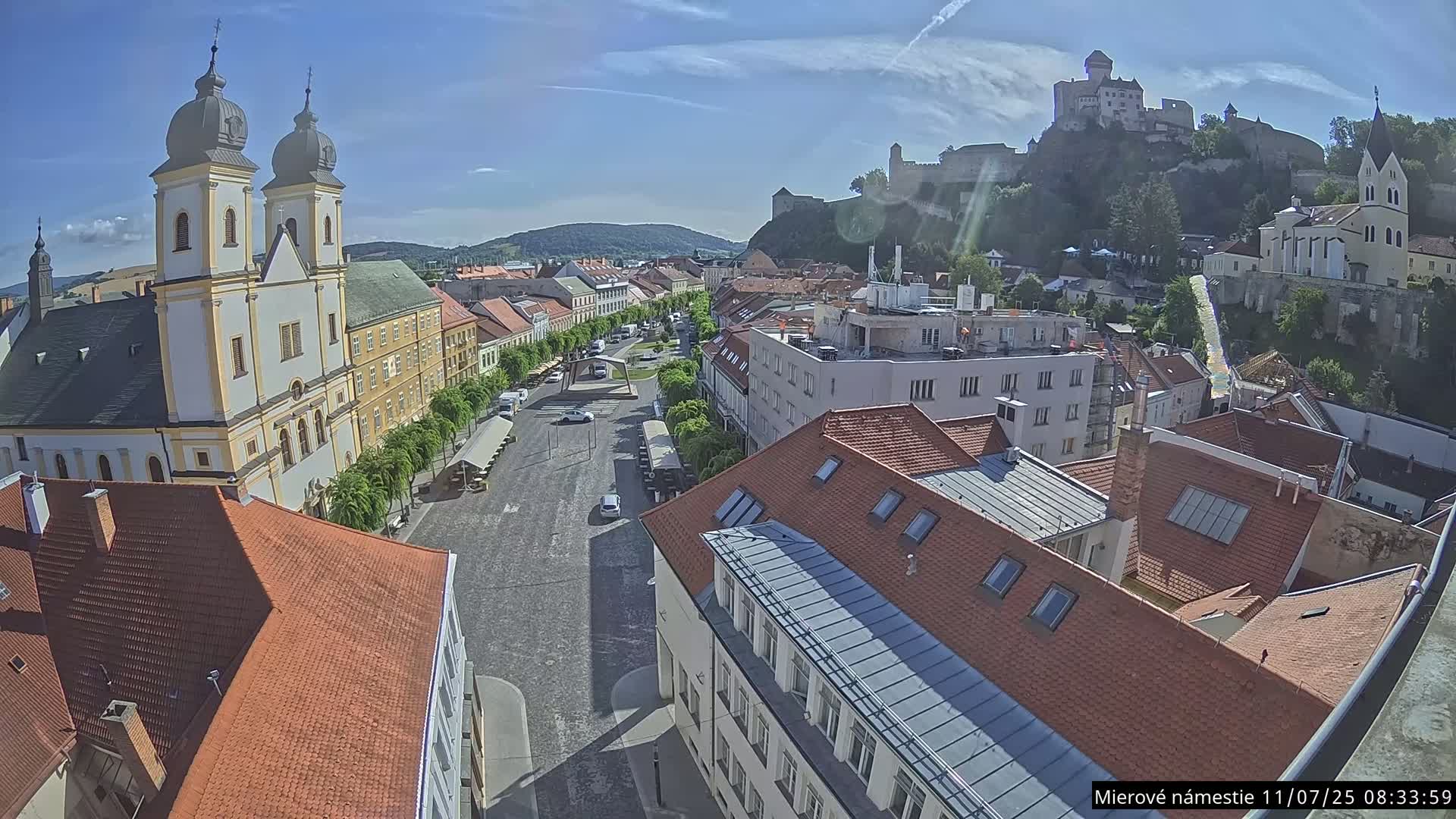 Trenčín, Piaristický kostol sv. Františka Xaverského Church & Trenciansky Hrad (Ttencin Castle) at Mierové námestie Square East View Live Cam - Trencin, Okres Trencin, Slovakia 